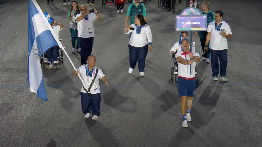 Herbert Aceituno porta la bandera de El Salvador en la ceremonia. ,image_description: