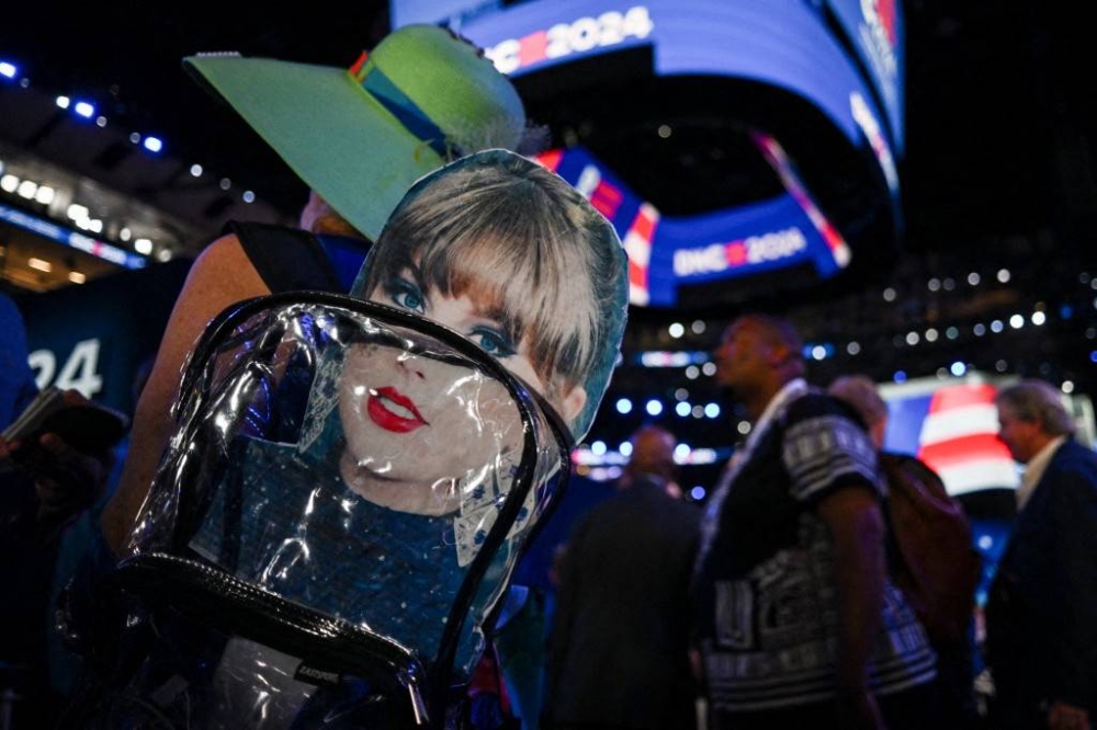 La imagen de Taylor Swif luce en la mochila de una asistente a la Convención Nacional Demócrata que tuvo lugar hace unos días en Chicago, Illinois. Brandon Bell/Getty Images/AFP,image_description:2024 Democratic National Convention: Day 3