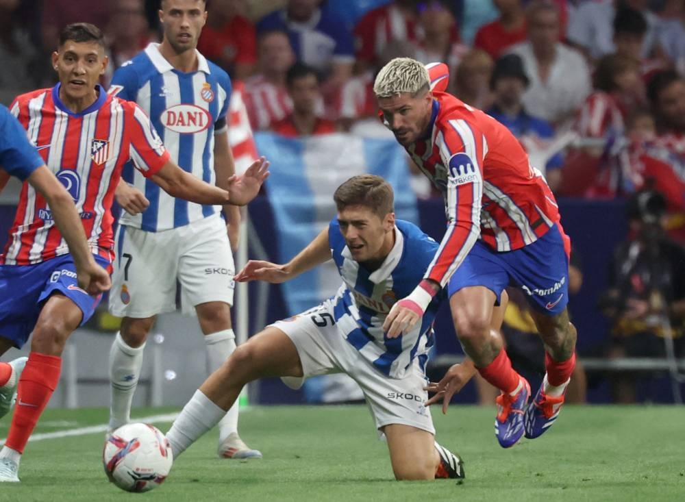 Rodrigo De Paul, del Atlético, disputa la pelota José Gragera, del Espanyol. / AFP,image_description: