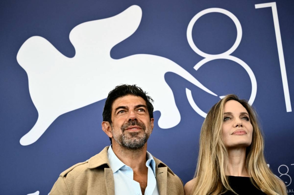 El actor italiano Pierfrancesco Favino y  Angelina Jolie este jueves en La Mostra. Photo by Marco BERTORELLO / AFP,image_description: