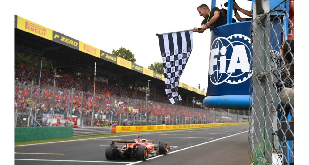 Charles Leclerc recibe la bandera a cuadros, en manos del exfutbolista Alessandro Del Piero. / AFP,image_description: