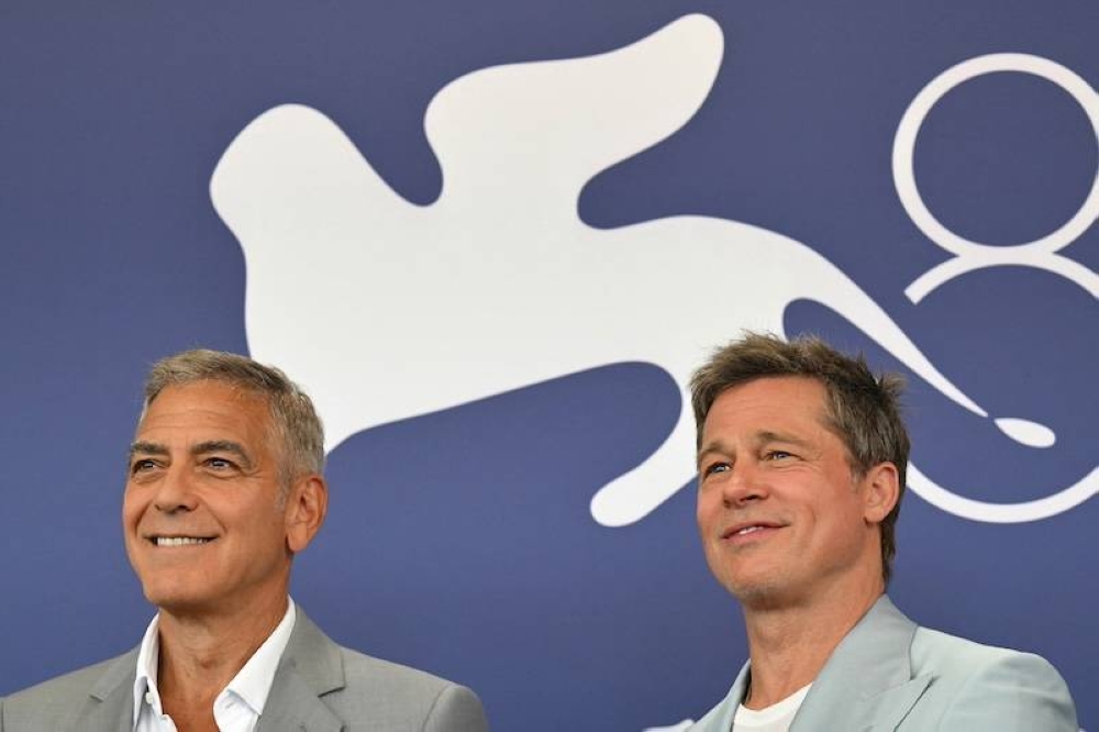 Los actores George Clooney izq y Brad Pitt, al llegar al Festival de Cine de Venecia este domingo./AFP ,image_description: