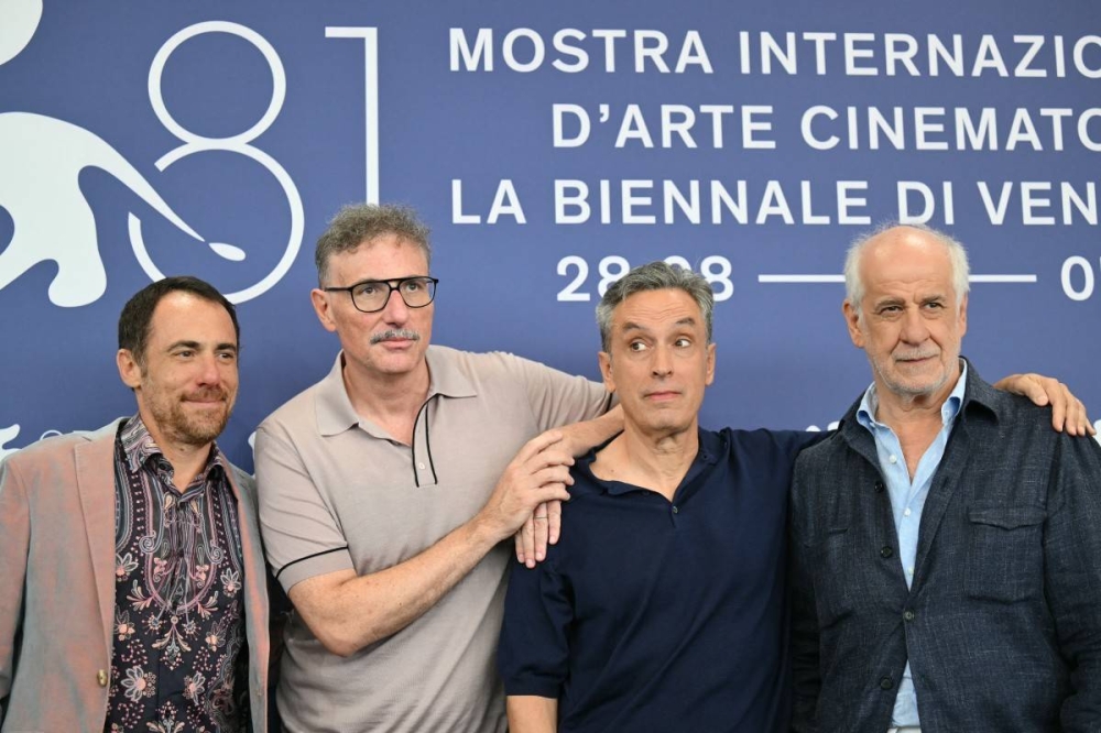 El actor Elio Germano, los directores Antonio Piazza y Fabio Grassadonia y el actor Toni Servillo en el estreno de Iddu Sicilian Letters este jueves en Venecia. Photo by Alberto PIZZOLI / AFP,image_description: