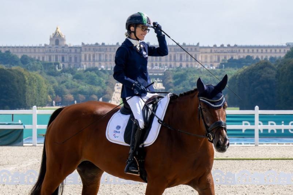 La italiana Sara Morganti montando a Mariebelle reacciona después de ganar la medalla de plata en el Evento Paraecuestre de estilo libre individual  Grado I en el Palacio de Versalles en los Juegos Paralímpicos París 2024. / AFP.,image_description: