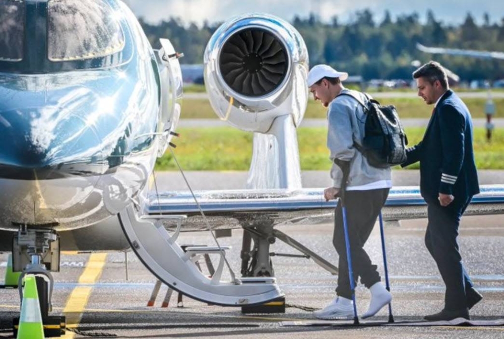 Odegaard aborda el avión de regreso asistido por muletas. ,image_description: