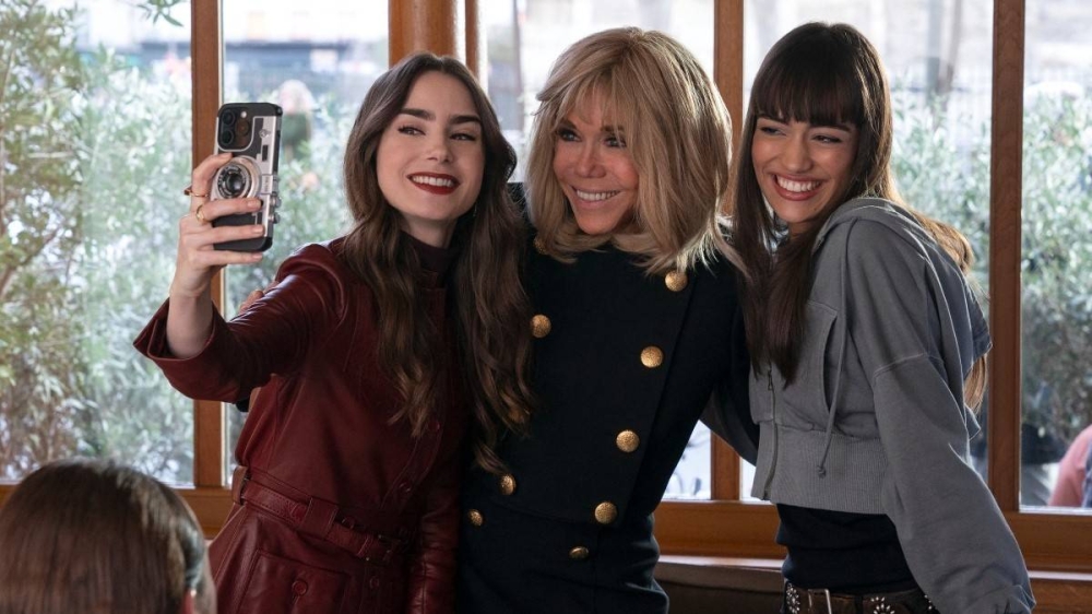 Lily Collins, Brigitte Macron y Thalia Besson en Emily in Paris. Photo by Handout / Netflix / AFP,image_description: