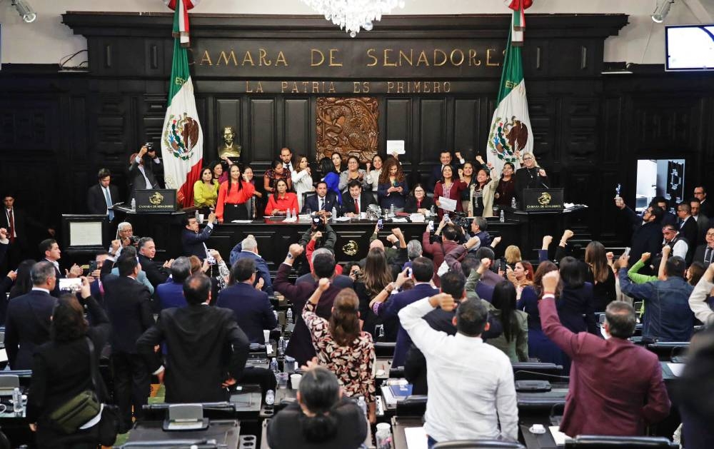 Los miembros del Senado de México celebran después de aprobar la controvertida reforma judicial en la cámara del Senado en la Ciudad de México el 11 de septiembre de 2024/Cesar Sánchez /AFP.,image_description: