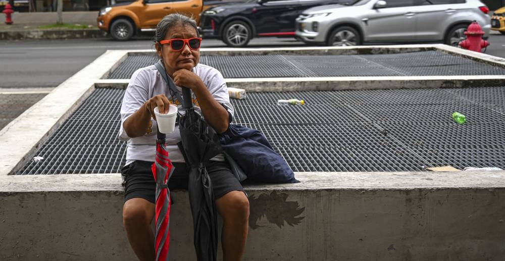 Una mujer pide dinero en la calle de la ciudad de Panamá, el 12 de septiembre de 2024/Foto por Martin Bernetti AFP.,image_description: