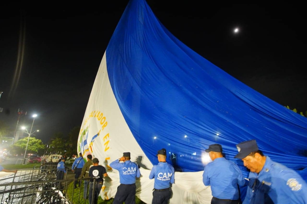 Personal de la alcaldía y del CAM izando la bandera la noche del jueves. / @PrensaAMSSC