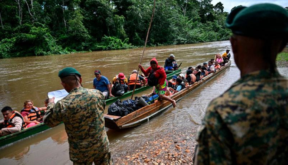 En un intento por controlar la migración por Darién, el gobierno panameño ha cerrado varios caminos por la selva, lo que ha obligado a los migrantes a usar corredores humanitarios controlados y vigilados por la policía.  / AFP,image_description: