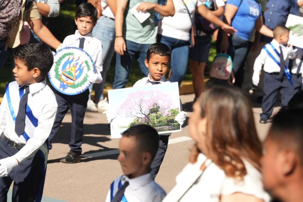 Niños portando el escudo y el árbol nacional. / @SantaTeclaSV. 