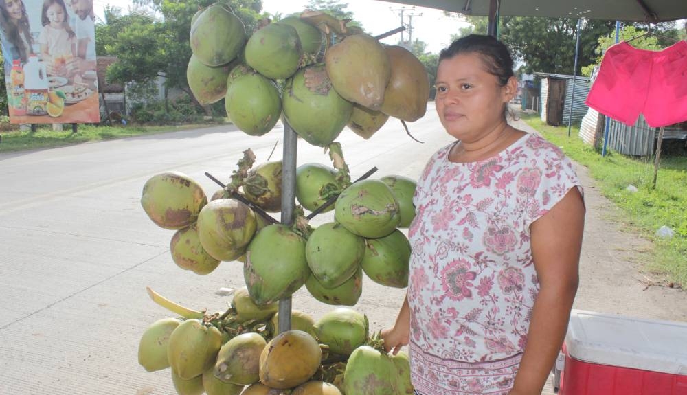 Nohemy Fuentes aseguró que incrementó el comercio de su venta de cocos, empiñadas y ropa de baño en el último año debido al aumento de la oferta comercial en la zona del redondel Surf City. /Francisco Vallen,image_description: