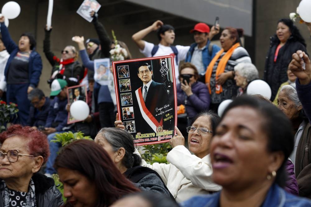 Partidarios del fallecido expresidente peruano Alberto Fujimori asisten a las afueras del Ministerio de Cultura durante su funeral de Estado en Lima el 14 de septiembre de 2024. /AFP,image_description: