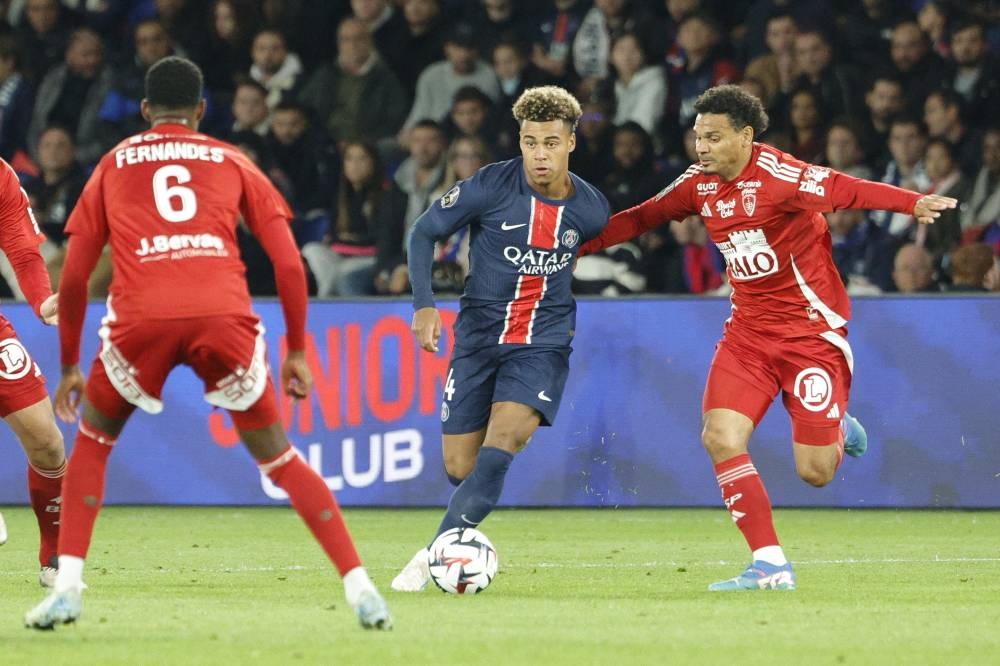 Desire Doue, del PSG, conduce el balón ante la marca de Kenny Lala, del Brest. / AFP,image_description: