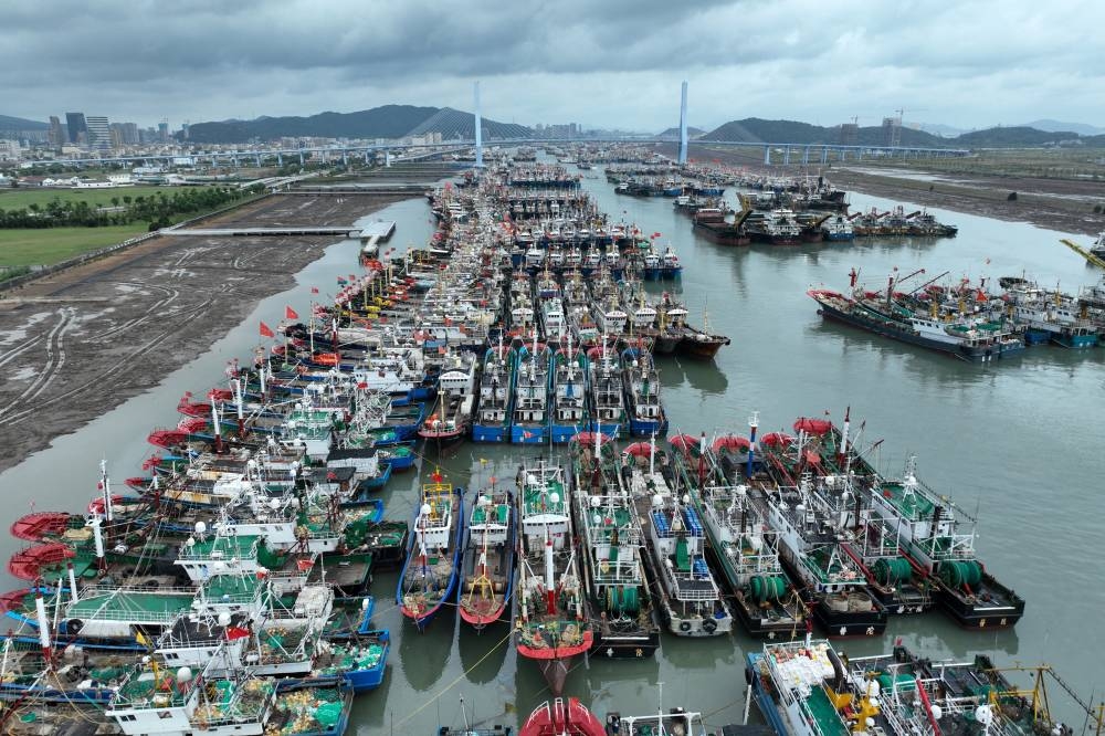 Los barcos pesqueros se refugian en el puerto de Zhoushan, en la provincia oriental china de Zhejiang, antes de la llegada del tifón Bebinca. /AFP,image_description: