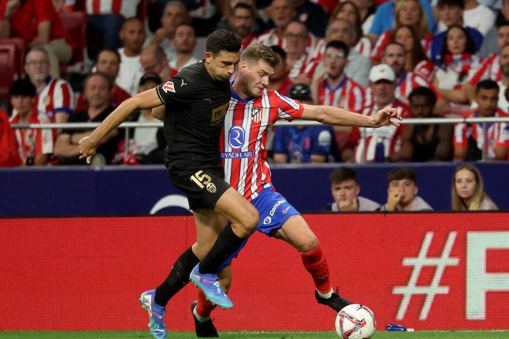 El centrocampista español del Valencia, César Tárrega, lucha por el balón con el delantero noruego del Atlético de Madrid, Alexander Sorloth/PierrePhilippe Marcou AFP.,image_description: