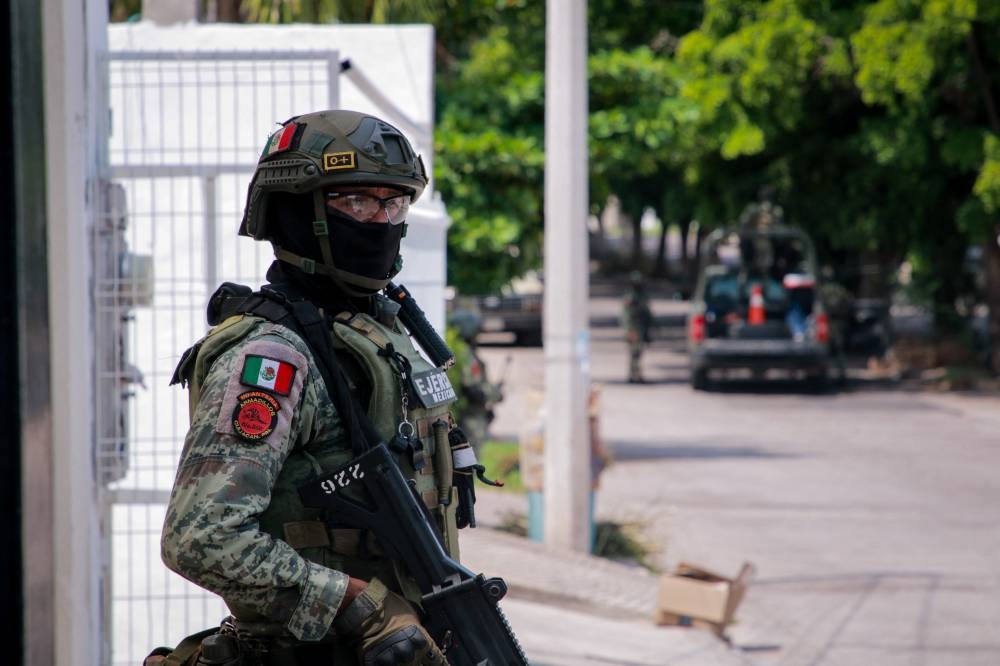 Un miembro del Ejército Mexicano hace guardia luego de un ataque armado contra la fachada de un negocio de venta de autos nuevos y usados u200bu200ben Culiacán, Estado de Sinaloa, México, el 12 de septiembre de 2024/ Foto Iván Medina AFP.,image_description: