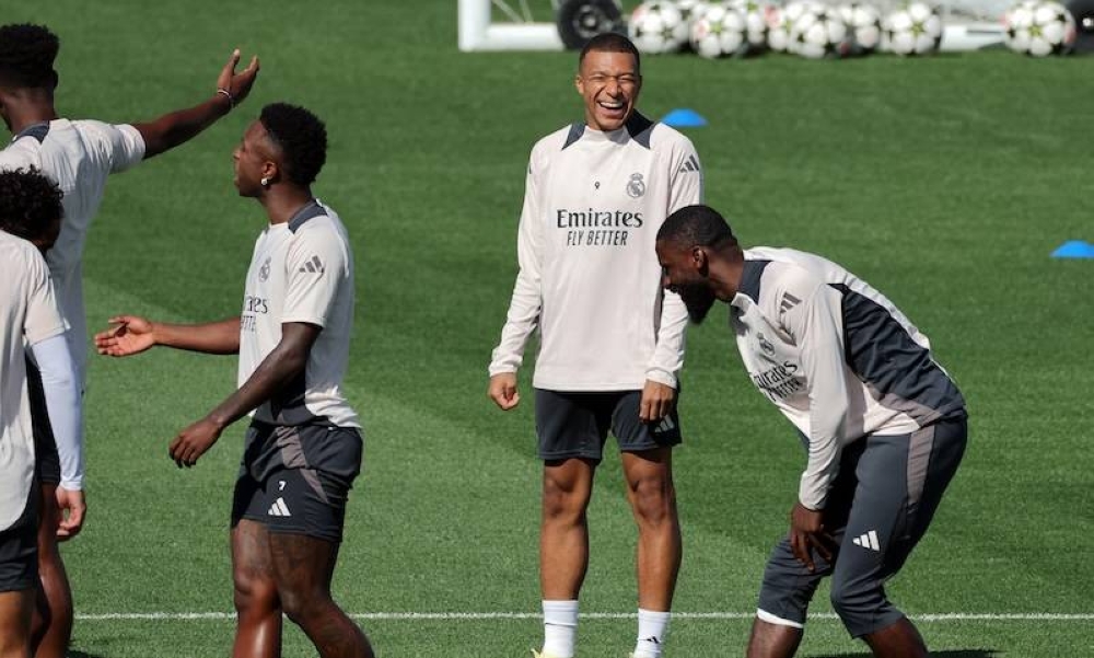 El delantero francés del Real Madrid, Kylian Mbappé C, asiste a una sesión de entrenamiento en vísperas de su partido de fútbol de la UEFA Champions League contra el Stuttgart VFB en las instalaciones de entrenamiento del club en Valdebebas, en las afueras de Madrid./AFP ,image_description: