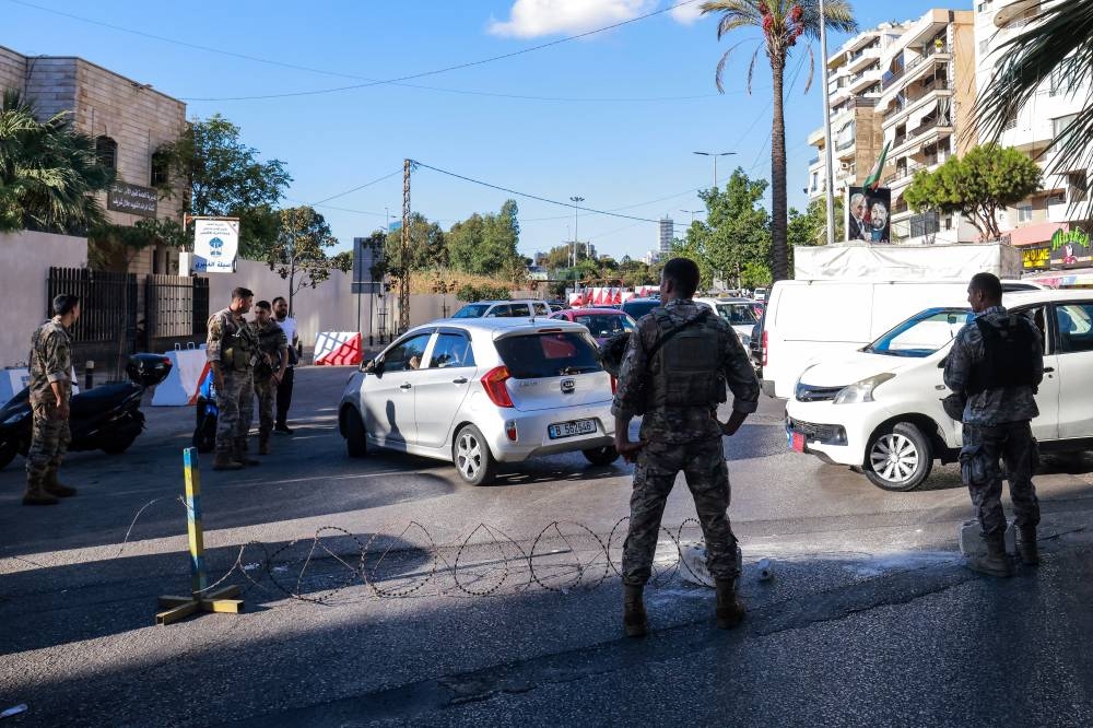 Soldados del ejército libanés bloquean la entrada de un suburbio del sur de Beirut el 17 de septiembre de 2024, después de que explosiones afectaran a varios bastiones de Hezbolá en todo el país en medio de tensiones transfronterizas en curso entre Israel y combatientes de Hezbolá. / AFP,image_description: