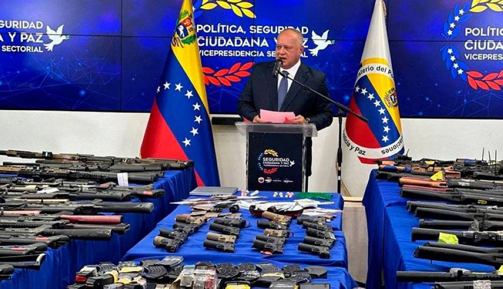 Diosdado Cabello, ministro del interior y justicia de Venezuela muestra las armas decomisadas en la operación. / AFP,image_description: