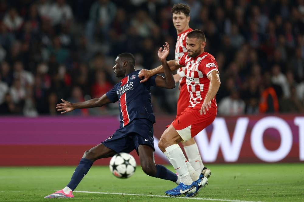 Randal Kolo Muani, del PSG, disputa la pelota con David López. / AFP,image_description: