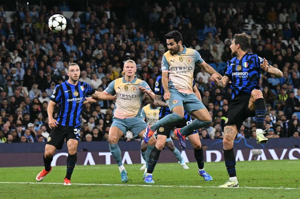 El cabezazo de Ilkay Gundogan, del City, ante la mirada de propios y extraños. / AFP,image_description: