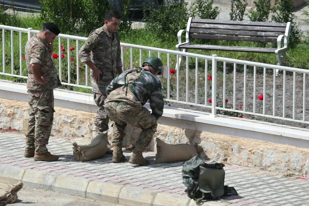 Esta imagen muestra a las fuerzas del ejército libanés preparándose para destruir en una explosión controlada un dispositivo de comunicación encontrado en el suelo en el sur del Líbano, entre las aldeas de Burj al Muluk y Klayaa, el 19 de septiembre de 2024. Foto de Rabih DAHER / AFP,image_description: