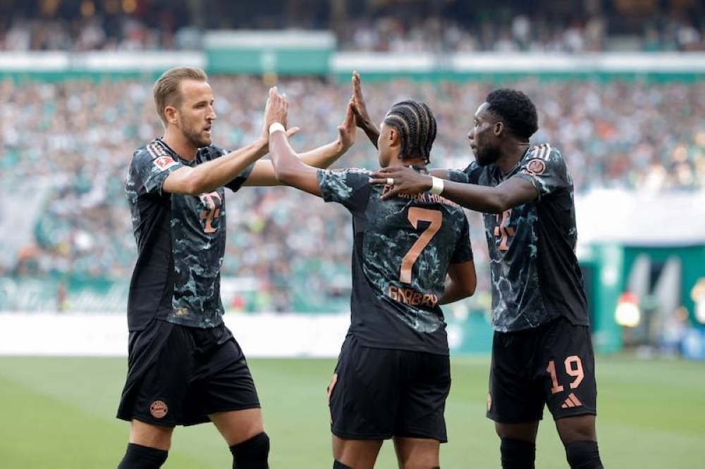 El delantero alemán del Bayern Munich Serge Gnabry C celebra después de anotar el gol del 05 con el delantero inglés del Bayern Munich Harry Kane Izq y el defensor canadiense del Bayern Munich, Alphonso Davies D durante el partido de fútbol de la primera división alemana Bundesliga entre SV Werder Bremen y FC Bayern Munich en Bremen/ AFP ,image_description: