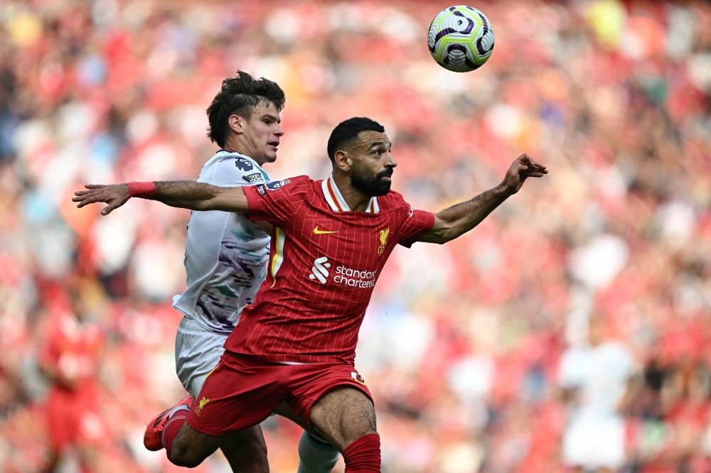 Mohamed Salah, del Ñiverpool, se anticipa al húngaro Milos Kerkez.  / AFP,image_description: