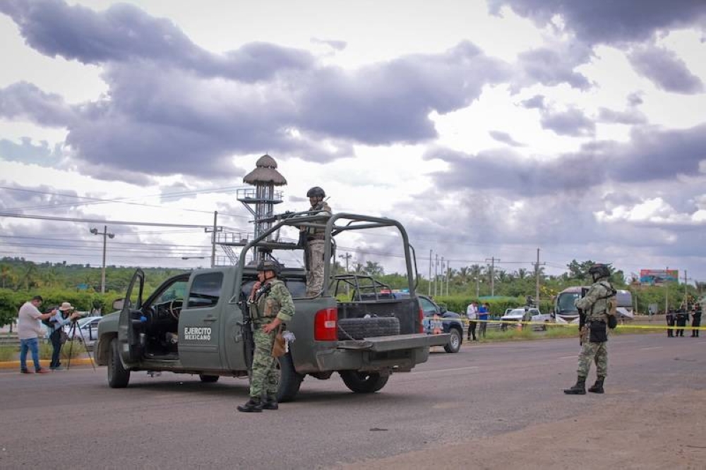 Soldados del Ejército mexicano vigilan el área donde aparecieron cinco cadáveres en una calle de Culiacán, en el estado de Sinaloa/ AFP,image_description: