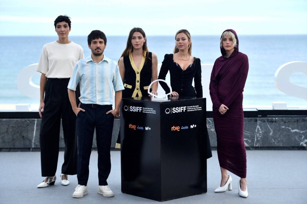 La guionista Isabel Pena, el direcor Pedro Martín Calero, la actriz francesa Mathilde Ollivier, la española Ester Exposito y la argentina Malena Villa llegaron a San Sebastián este miércoles. Photo by ANDER GILLENEA / AFP,image_description: