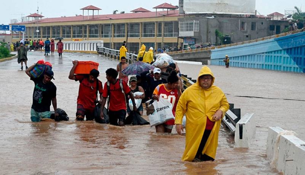 Residentes de Acapulco salieron de sus hogares con las pocas cosas que pudieron cargar por la inundación. / AFP