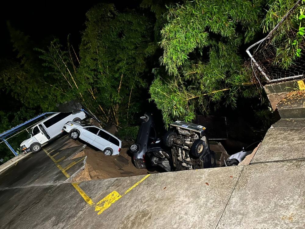 El muro cedió en la colonia San Ernesto y cinco vehículos cayeron a un río, dejando daños materiales. / PNC.,image_description: