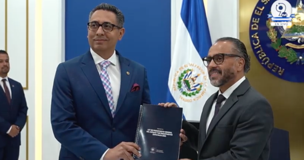 El ministro de Hacienda, Jerson Posada Molina, presenta el proyecto de presupuesto estatal del año 2025, al presidente legislativo, Ernesto Castro. / Imagen de video de la Asamblea Legislativa.,image_description: