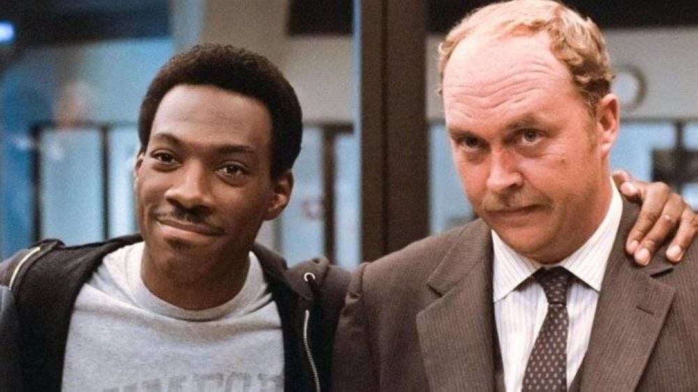 John Ashton en una de las películas del Beverly Hills Cop junto a Eddie Murphy.,image_description: