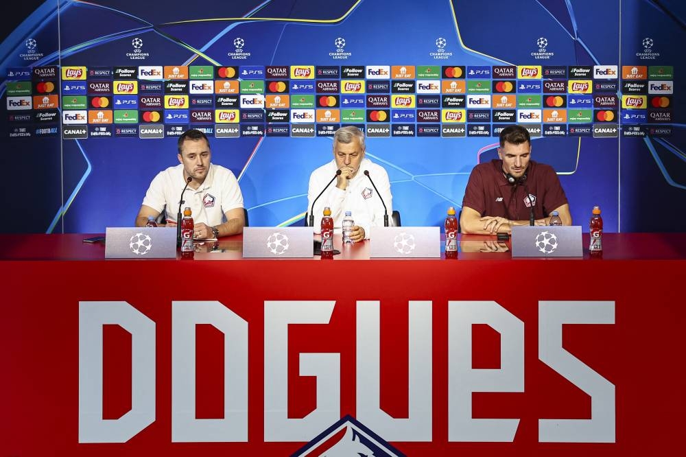 De izquierda a derecha El director de prensa y relaciones públicas del Lille, Nicolas Parent, el entrenador francés del Lille, Bruno Genesio, y el defensa belga 12 del Lille, Thomas Meunier, ofrecen una conferencia de prensa en vísperas de su partido de fútbol de la Liga de Campeones de la UEFA contra el Real Madrid CF, en el Centro de formación Domaine de Luchin en Camphin en Pevele, cerca de Lille, norte de Francia, el 1 de octubre de 2024. / AFP,image_description: