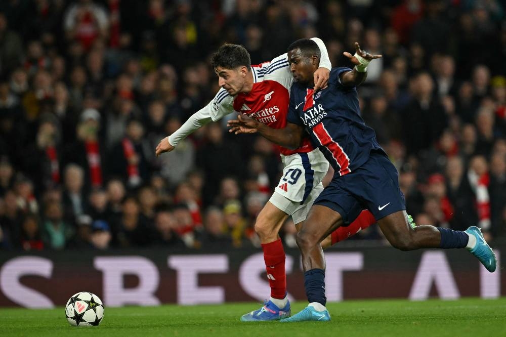 Kai Havertz, del Arsenal, lucha con Willian Pacho, del PSG. / AFP,image_description: