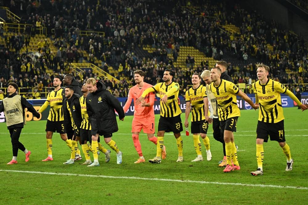 Los jugadores del Borussia Dortmund saludan a su afición tras el 71 al Celtic. / AFP,image_description: