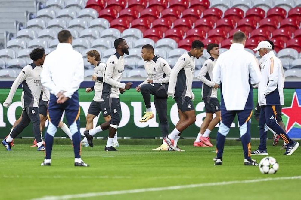 El delantero francés del Real Madrid, Kylian Mbappé C, participa en una sesión de entrenamiento con sus compañeros de equipo en vísperas de un partido de fútbol de la UEFA Champions League contra el Lille LOSC, en el Stade PierreMauroy en Villeneuved039Ascq, norte de Francia./ AFP,image_description: