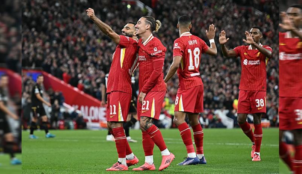 El delantero egipcio del Liverpool 11 Mohamed Salah celebra marcar el segundo gol del equipo con el defensor griego del Liverpool 21 Kostas Tsimikas durante el partido de fútbol de la Liga de Campeones de la UEFA entre Liverpool y Bolonia en Anfield en Liverpool/ Foto Paul Ellis AFP.,image_description: