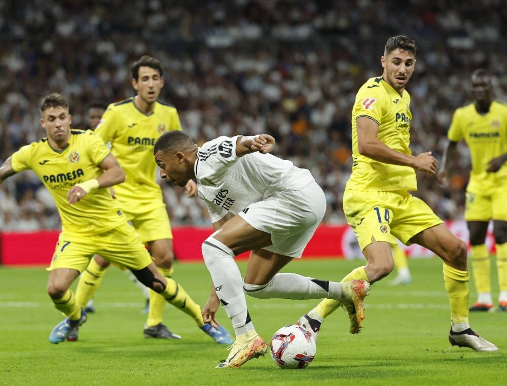 Kylian Mbappe, del Real Madrid, rodeado de jugadores del Villarreal. / AFP,image_description: