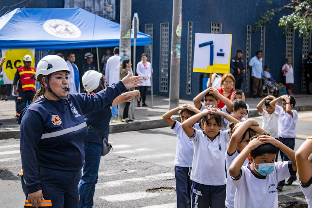 Personal de Protección Civil evacúa alumnos durante el simulacro de terremoto de 7.5 grados en el barrio San Jacinto de San Salvador./Alexander Montes,image_description: