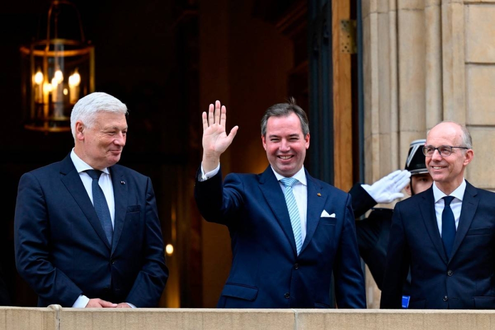 Guillermo de Luxembourgo centro saluda este martes desde el palacio de Luxemburgo.. Photo by JeanChristophe VERHAEGEN / AFP,image_description: