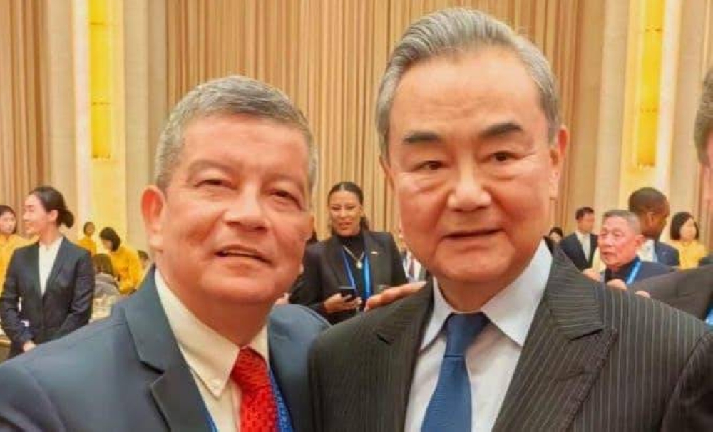 El secretario del FMLN, Manuel Flores, publicó esta fotografía con el canciller de China, Wang Yi. / FMLN.,image_description: