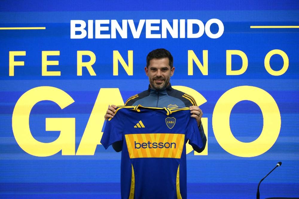 Fernando Gago posa con la camisa de Boca Juniors, club en el que tuvo su etapa como futbolista. / AFP,image_description: