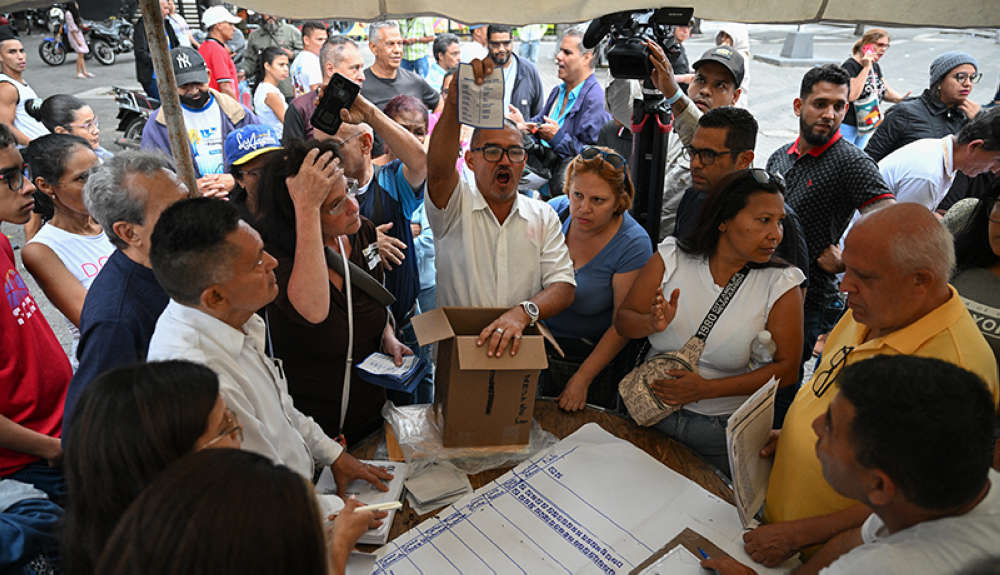 Miembros de una mesa electoral cuentan los votos despueu0301s de las elecciones primarias de la oposiciou0301n en Caracas.AFP2,image_description: