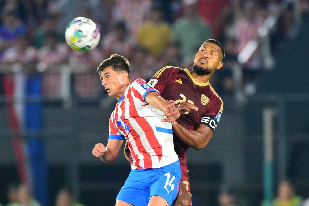 El paraguayo Andrés Cubas y el venezolano Salomón Rondón en el juego de Eliminatorias. / AFP,image_description: