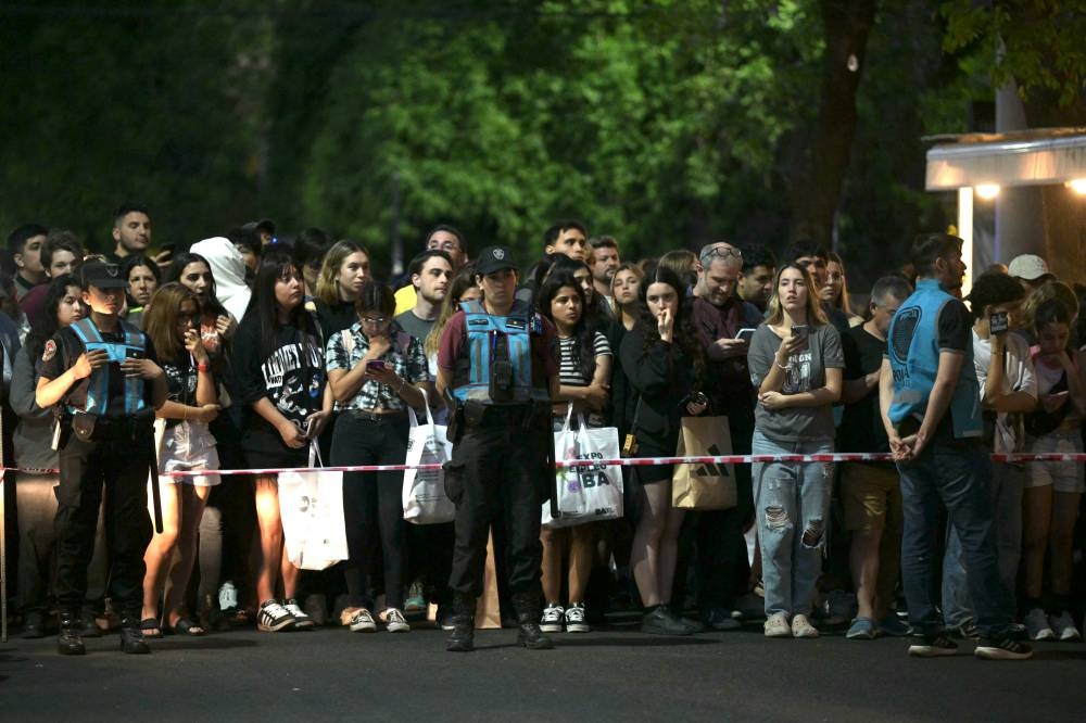 Fans del cantante británico Liam Payne, exmiembro del grupo One Direction, esperan cerca del hotel donde murió en Buenos Aires el 16 de octubre de 2024. JUAN MABROMATA / AFP