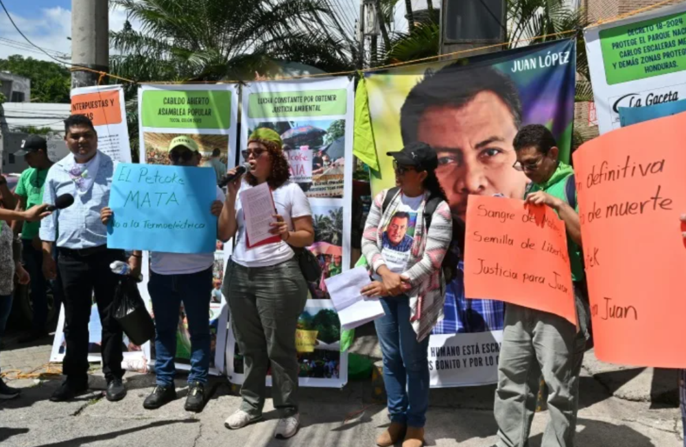 Integrantes del Comité Municipal de Defensa de los Bienes Comunes del Municipio de Tocoa, en el departamento de Colón, exigen justicia por el asesinato del ambientalista Juan López/ Foto Orlando Sierra AFP.,image_description: