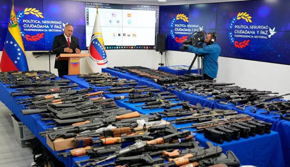 El ministro de Justicia de Venezuela, Diosdado Cabello, muestra las armas decomisadas por el gobierno. / AFP,image_description: